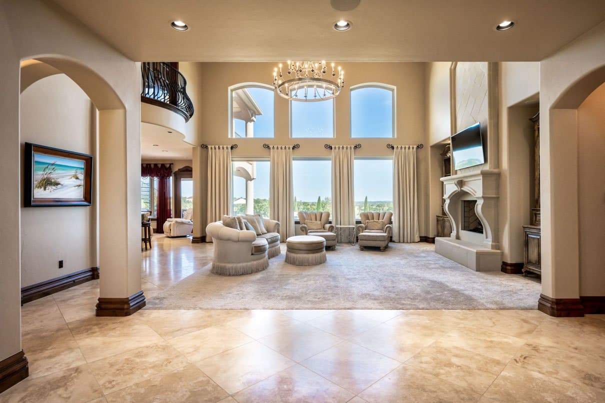 Sunlit double-height living room framed by arched openings and tall windows