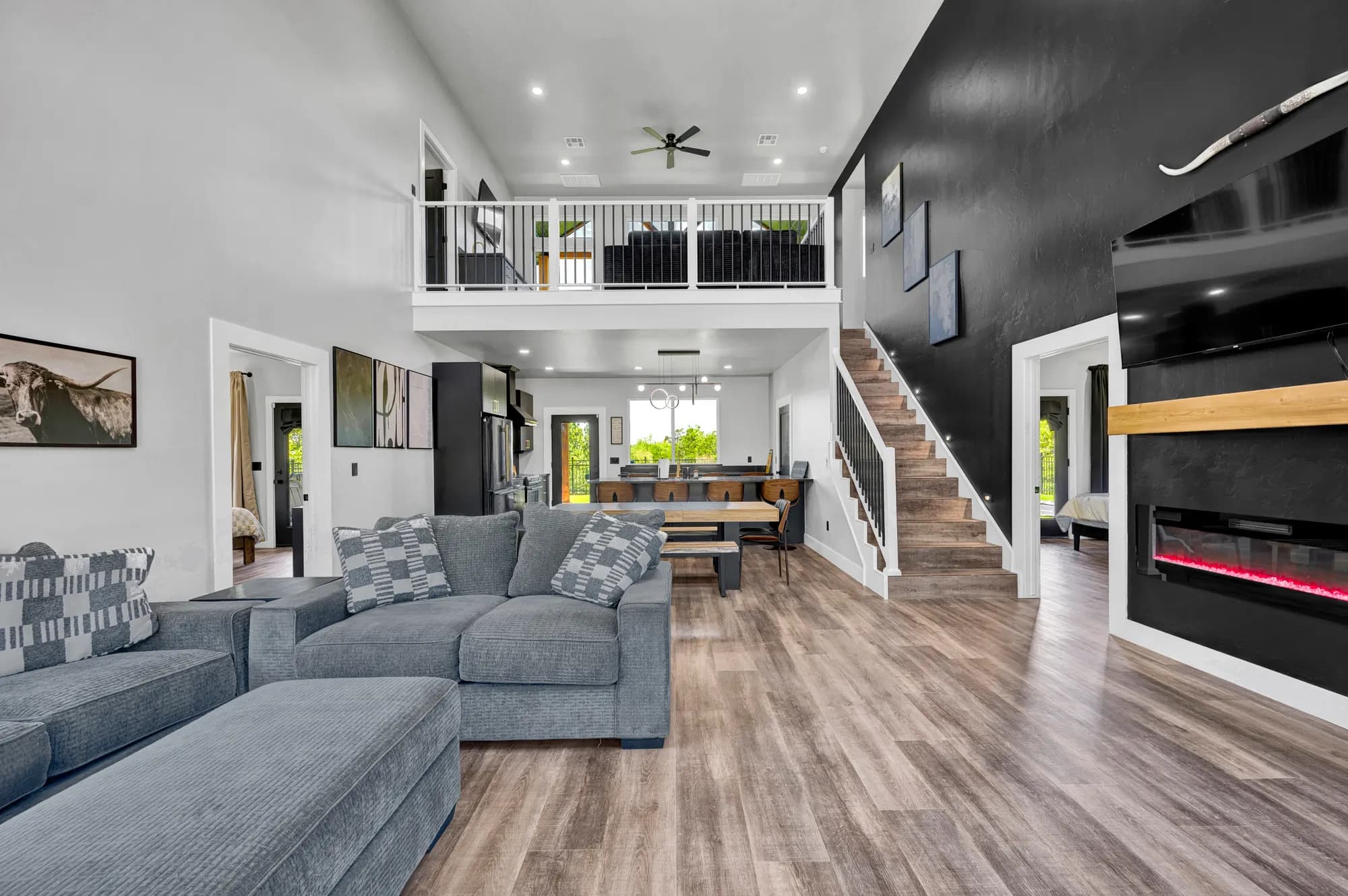 Lake house living room with a linear fireplace and a loft overlooking the space
